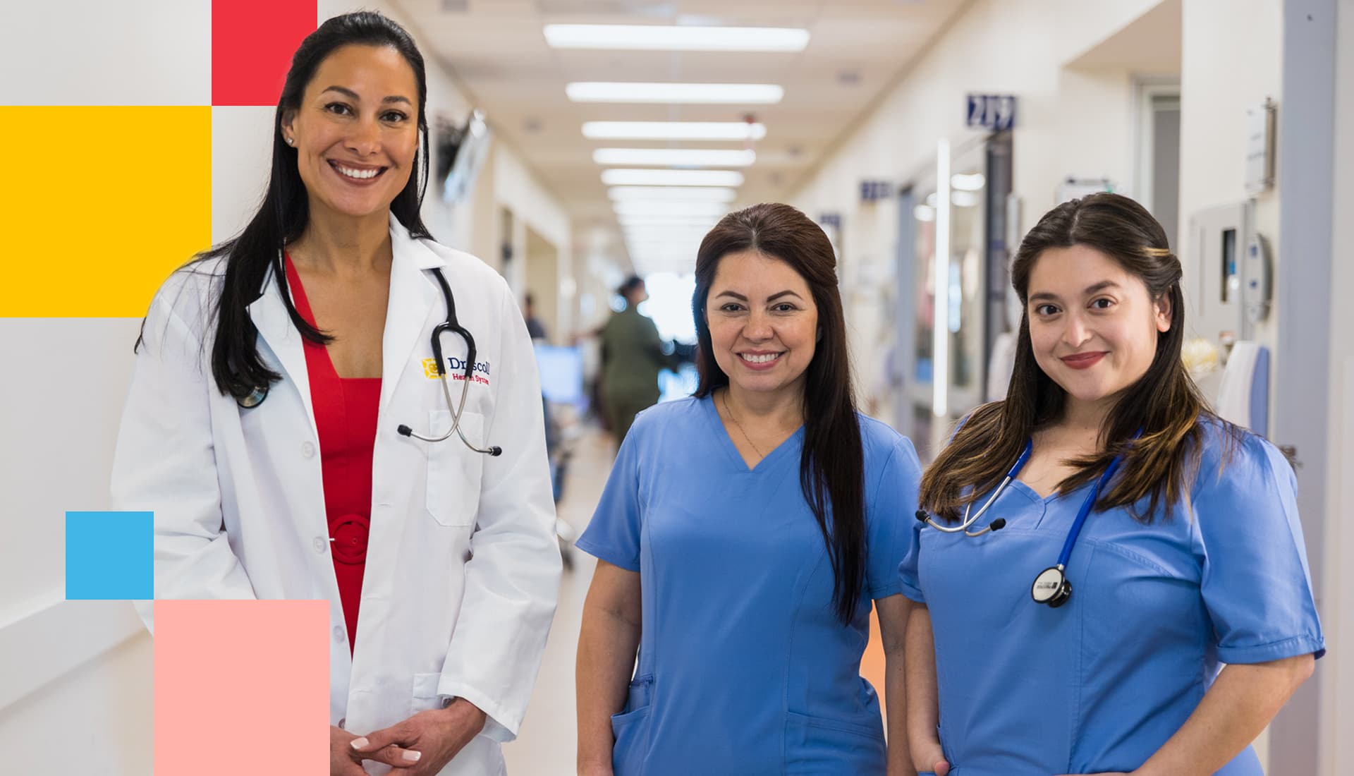 A Driscoll Children's Hospital physician and two nurses in scrubs smiling in a hospital corridor
